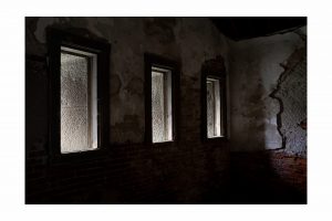 three windows in a dark wall